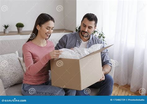 Young Couple Unboxing Cardboard Package Ordering At Home Stock Image