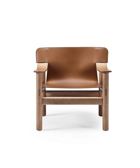 A Brown Leather Chair Sitting On Top Of A White Floor Next To A Wooden