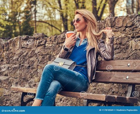 Trendy Blonde Female Relaxes Outdoor Drinking Takeaway Coffee While