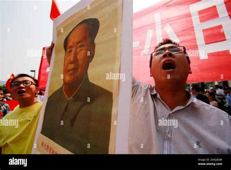 A Chinese Protester Holding A Portrait Of Former Chinese Leader Mao