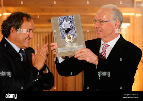 HANDOUT -Franz Beckenbauer (R) poses with his award next to Michel ...