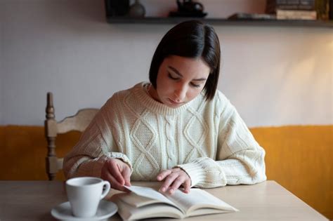 Premium Photo | Person in a cafe reading a book while having coffee