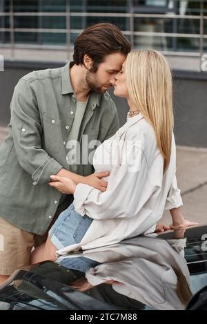 Sensual And Stylish Blonde Woman Seducing Handsome Bearded Man While Sitting In Modern Car