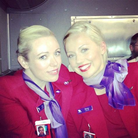 Two Women In Red Uniforms Smile For The Camera While Sitting Next To