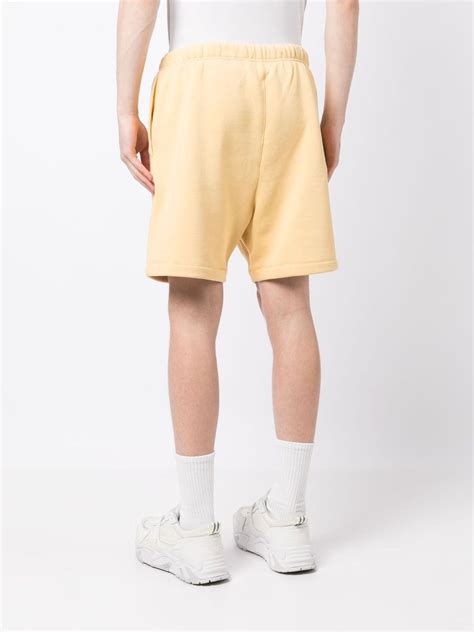 Fear Of God Essentials Logo Patch Track Shorts Yellow Farfetch Uk