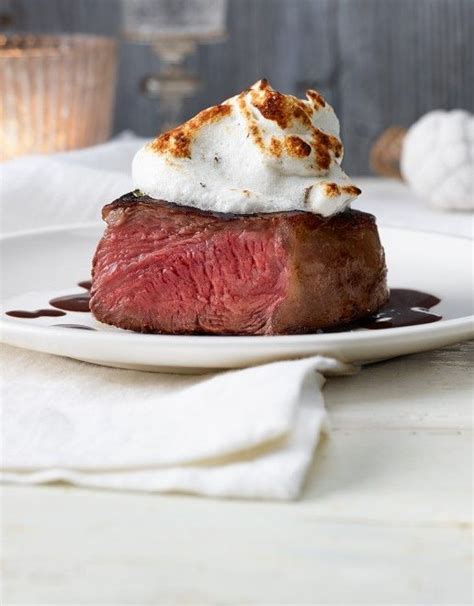 a piece of steak with whipped cream on top