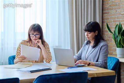 Two mature business women working in office with papers laptop 이미지