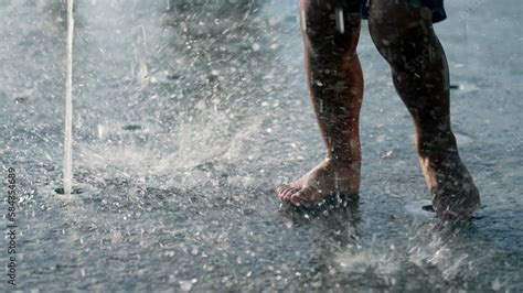 Child feet in splashing water playing at park water jet outdoors Stock ...