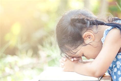 Cute Asian Little Child Girl Praying With Folded Her Hand Stock Photo