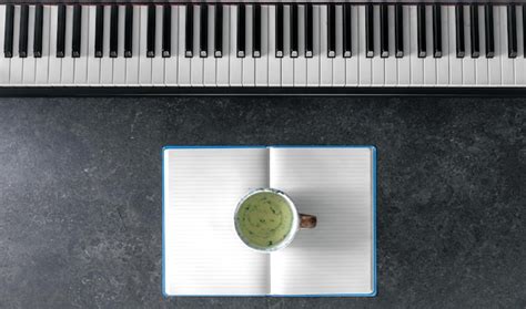 Free Photo Piano Open Notepad And Cup Of Tea On A Dark Background Top