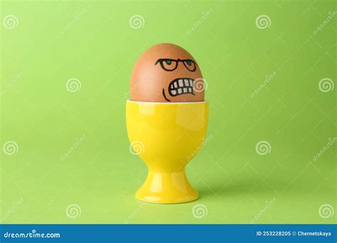 Egg With Drawn Angry Face In Cup On Green Background Stock Image