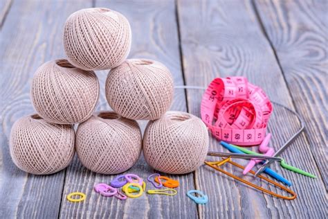 Bolas de hilo agujas de tejer cinta métrica y clips de papel sobre