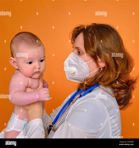 Woman Pediatrician Holding An Infant Baby In A Diaper In Her Hands Red