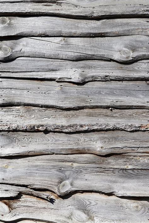 A Heavily Cracked Wooden Wall Made Of Old And Crooked Panels With