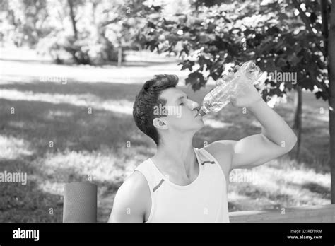 Deportista beber agua en parque en días soleados de verano natural del