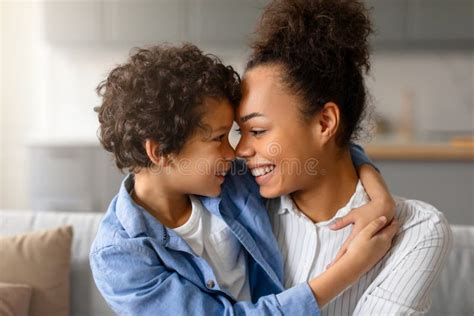 Black Mother And Son Sharing Joyous Forehead Touch At Home Stock Image