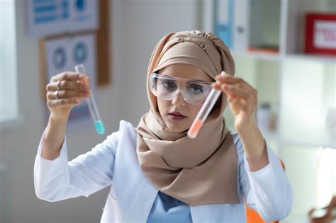 Premium Photo Two Test Tubes Dark Eyed Female Chemist Wearing Glasses Holding Two Test Tubes