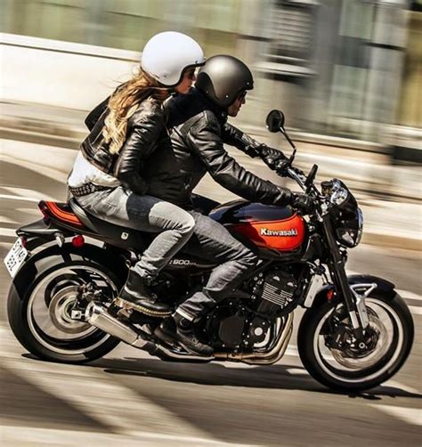 Two People Riding On The Back Of A Motorcycle