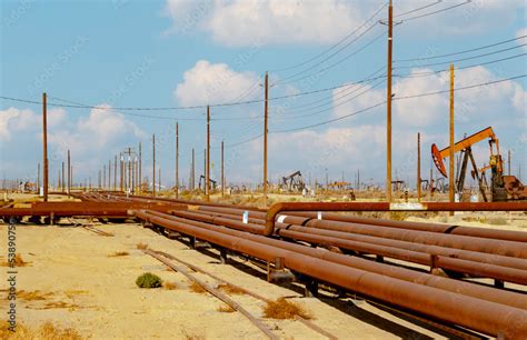 Multiple Oil Pumps In A Desert Oil Field Pumping Crude Oil Into An