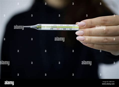 Female Holds Mercury Thermometer In Hand In Front Of Her With 366