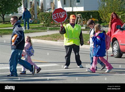 Elementary School Crossing Guard Provides Safety To Children Crossing