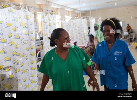 A Nurse And A Midwife Smile At Each Other During A Busy Shift On The