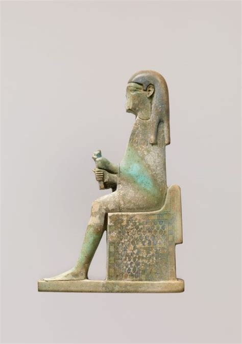 An Ancient Egyptian Statue Sitting On Top Of A Chair With A Bird In It