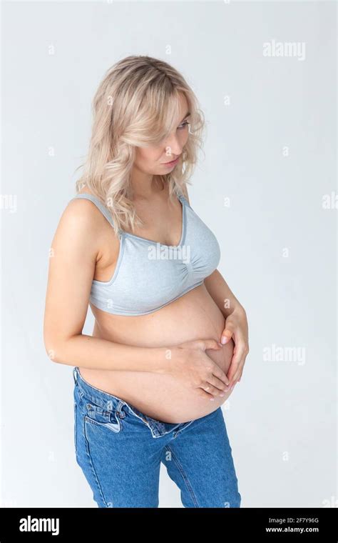 Beautiful Young Pregnant Blonde Woman In Blue Jeans And A Top For