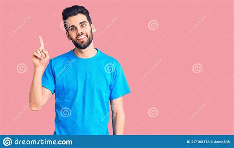 Young Handsome Man With Beard Wearing Casual T Shirt Pointing Finger Up