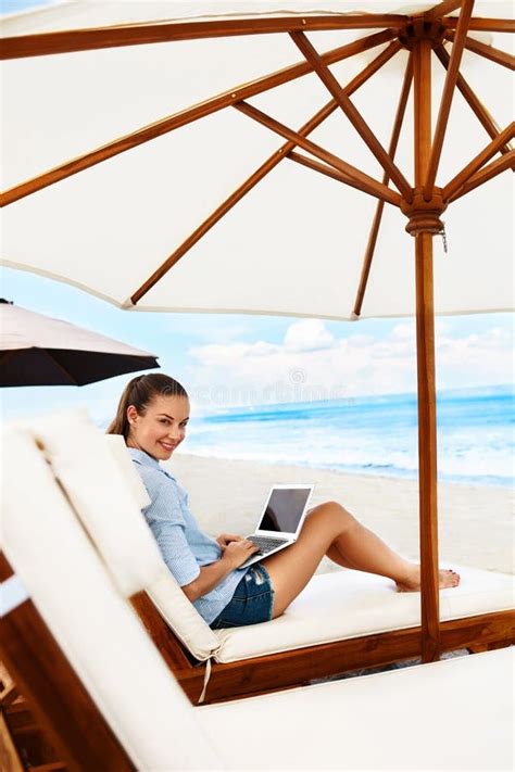 Trabalho Do Ver O Mulher Que Relaxa Usando O Computador Na Praia