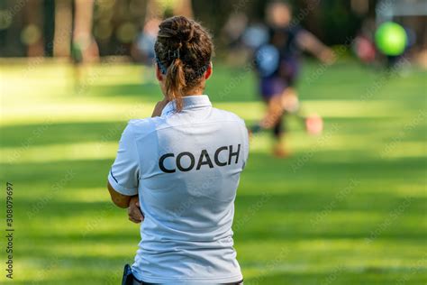 Back View Of A Female Sport Coach Watching Her Team Compete At An