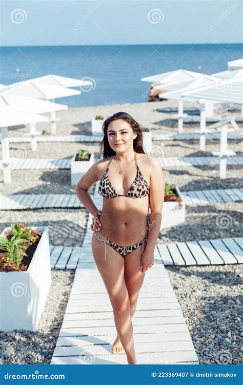 Beautiful Woman Brunette In Swimsuit Sunbathes On The Beach By The Sea Stock Image Image Of