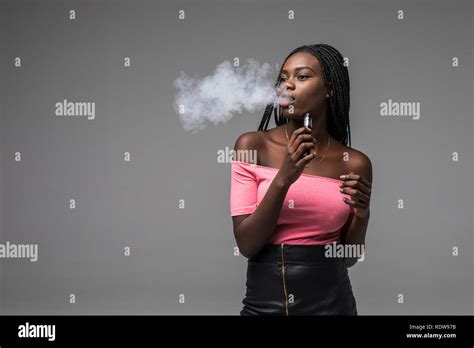 Young Beauty African Woman Smoke Vape E Cigarette On Gray Background