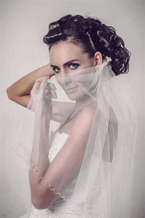 Beautiful Brunette Bride Holding Veil Over Her Smiling Face Stock Photo