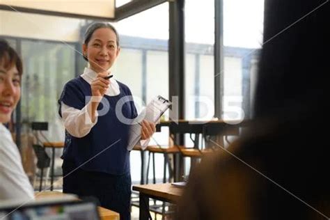 Smiling Mature Professor Pointing At College Student Who Wants To Ask Something Hi Res 274538088