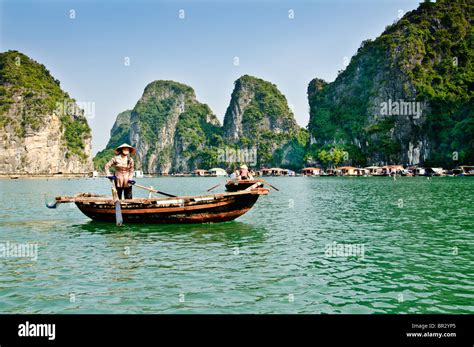 Vietnamese in a boat outside a fishing village in Halong Bay, Vietnam ...