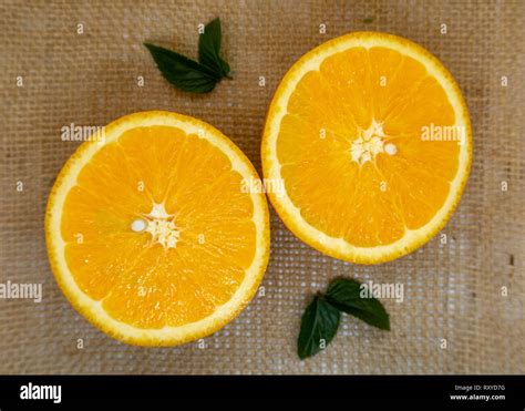 Cut Fresh Juicy Orange Halves On A Hessian Background Stock Photo Alamy