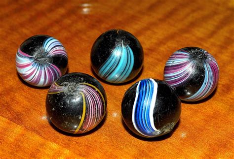 Four Marbles Sitting On Top Of A Wooden Table