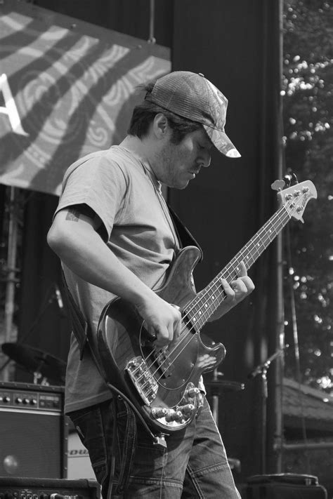 Black And White Photograph Of Man Playing Bass Guitar