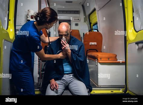 Nurse In Medical Uniform With Stethoscope And Man Sits In Oxygen Mask