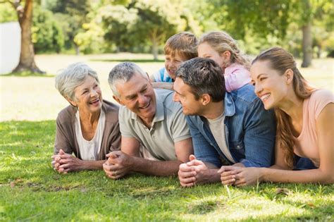 Familia Extendida Tumbado En La Hierba En El Parque Foto Premium