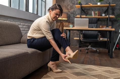 Premium Photo A Woman Taking Off Shoes On High Heels After A Long Day