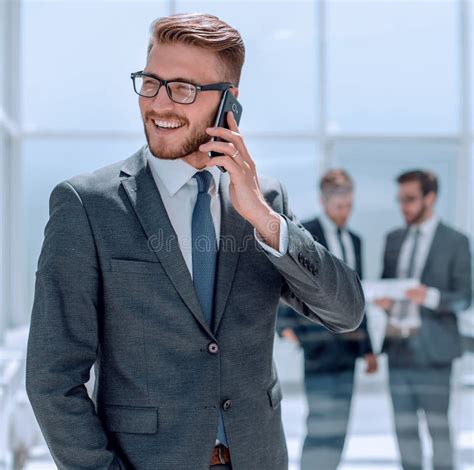 Businessman With Mobile Phone Standing Next To The Bank Office Stock