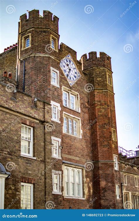 An Old Red Brick Building With A Clock Tower And Round Columns Stock