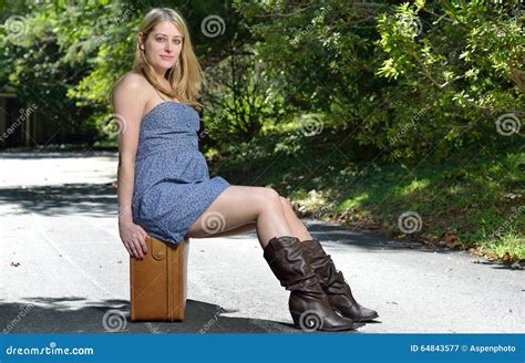 Attractive Blonde Woman Sits Outside With Suitcase Stock Image Image