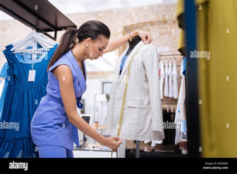 Focused Female Sale Assistant Measuring Jacket Length Stock Photo Alamy