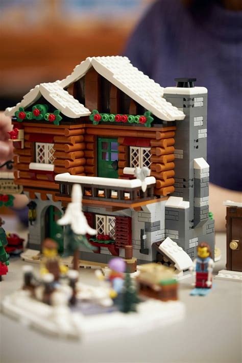 a lego model of a log cabin with snow on the roof