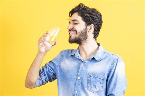 Homem Jovem Segurando Copo De Vidro Barbudo Sobre Fundo Amarelo