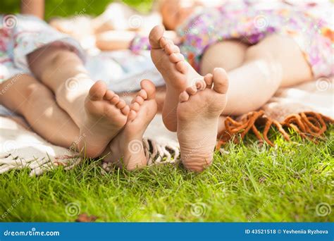 Deux Pieds De Soeurs Se Trouvant Sur L Herbe Au Parc Photo Stock