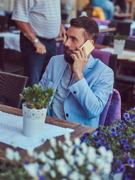 Fashionable Bearded Male With Stylish Haircut In Outdoor Cafe